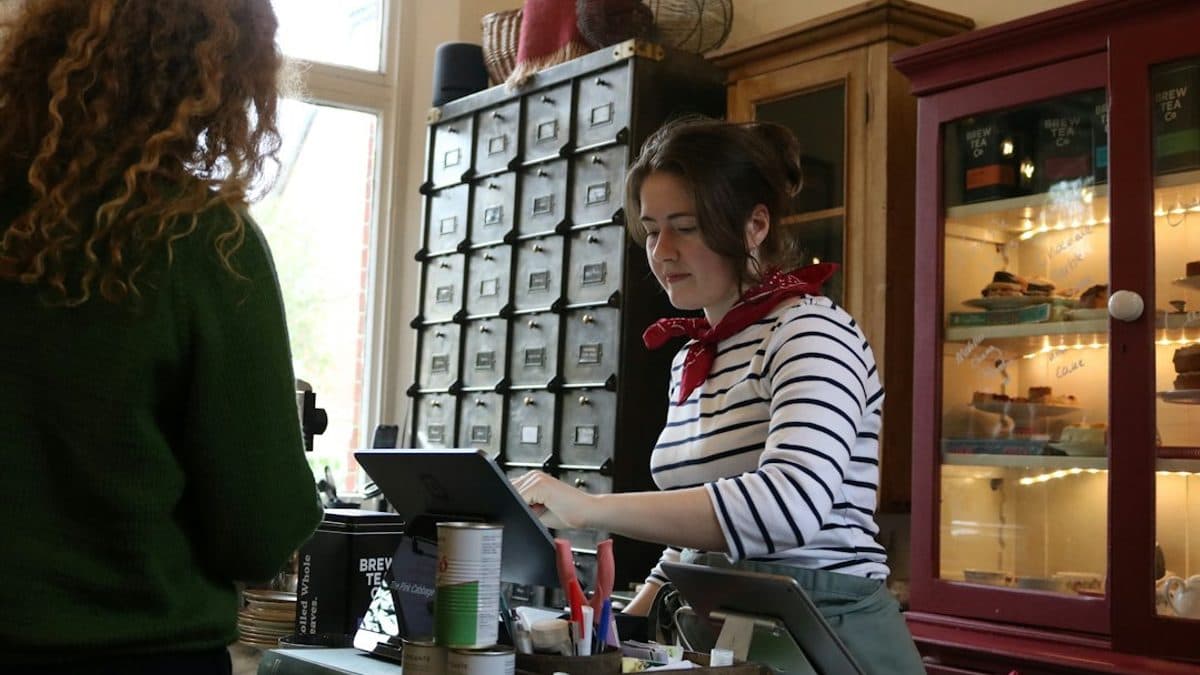 Shop staff using an internal tablet app at the counter, the kind of internal tool often built with vibe coding